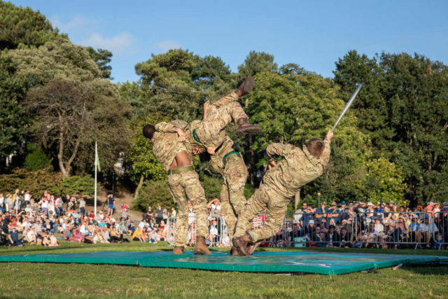 Three marine soldiers putting on a fighting display for the crowds in the gardens