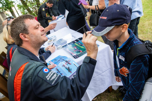 Blade pilot signing a fans hat at the Pilot meet and greet event in Bournemouth