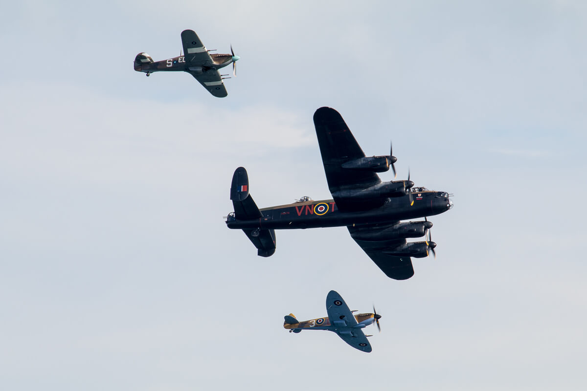 World war 2 memorial planes flying side by side as they entertain fans on the beach